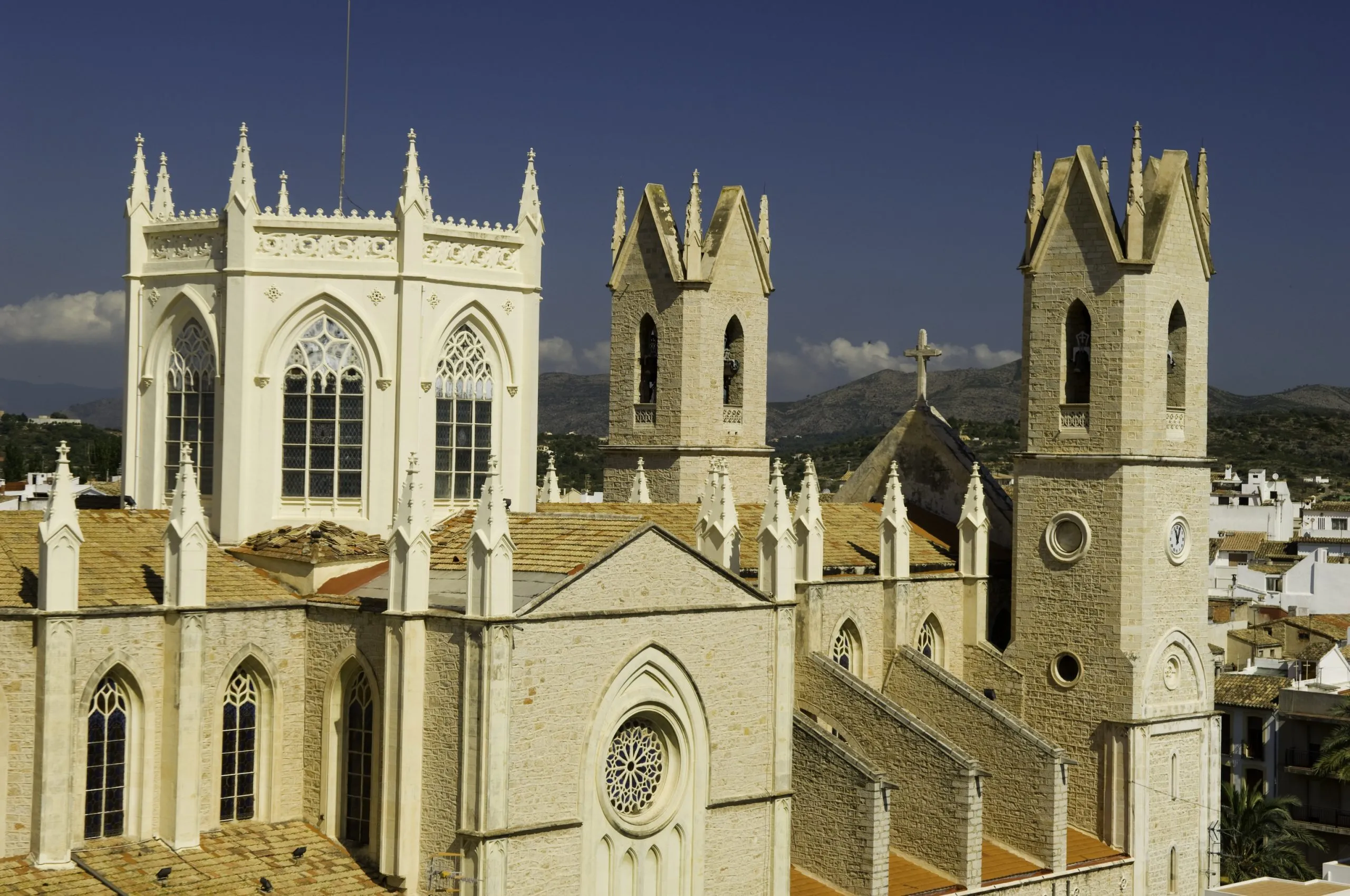 La iglesia de la Puríssima Xiqueta de Benissa, de piedra y estilo neogótico, alzándose sobre los tejados del casco antiguo